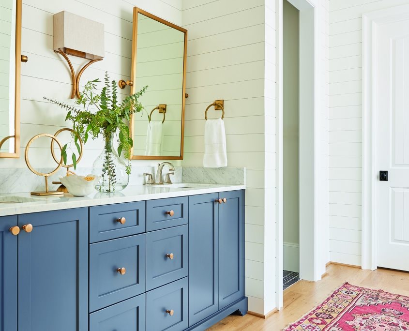 Gray blue cabinets. white shiplap walls, master bathroom, gold framed mirrors. Double bathroom vanity