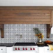 kitchen range hood made from quarter sawn white oak surrounded by white kitchen cabinets