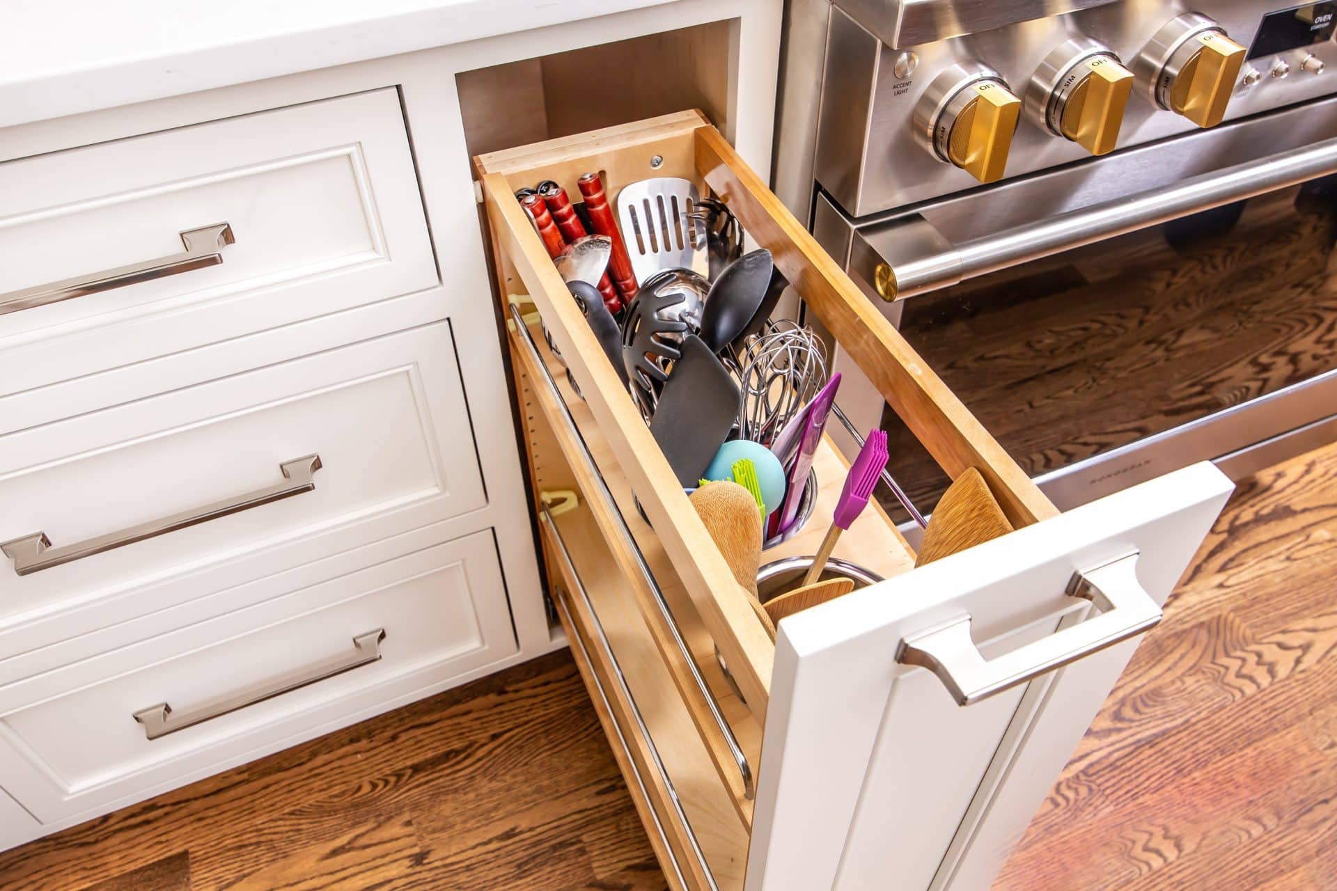 https://walkerwoodworking.com/wp-content/uploads/2023/02/Walker-Woodworking-custom-cabinets-utensil-canister-drawer-Belwith-keeler-hardware-pull-out-kitchen-hardware.jpg