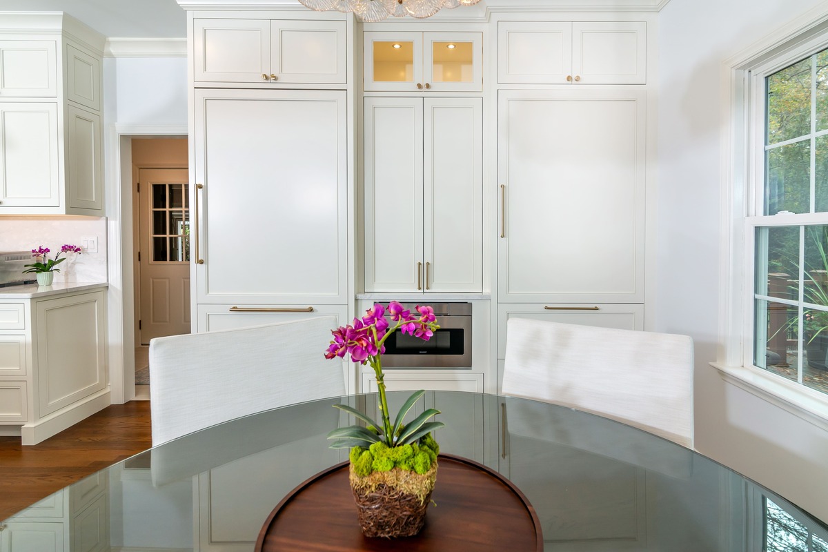 White cabinets with a dining table and a flower