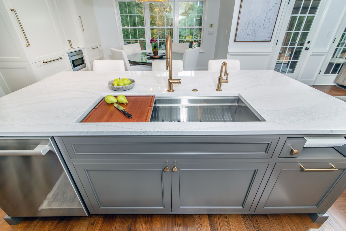 Grey kitchen island with a sink and white countertops