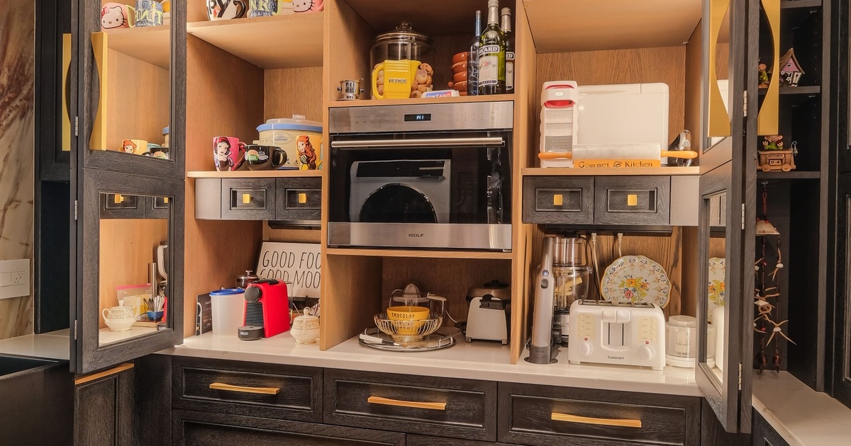 A butler pantry with custom oak cabinetry and a built in small oven and coffee maker