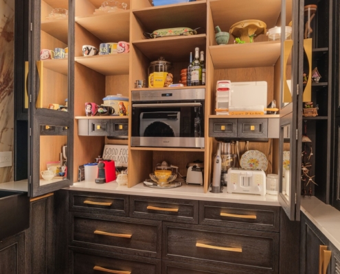 A butler pantry with custom oak cabinetry and a built in small oven and coffee maker
