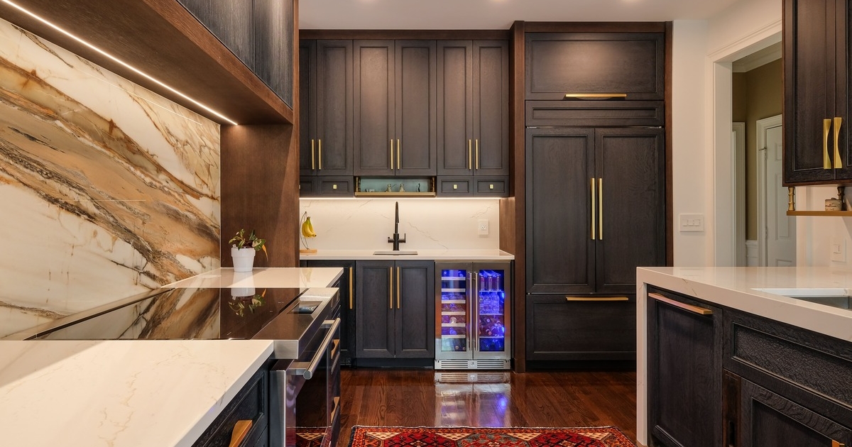 A kitchen with cabinets and paneled appliances with a custom rangehood