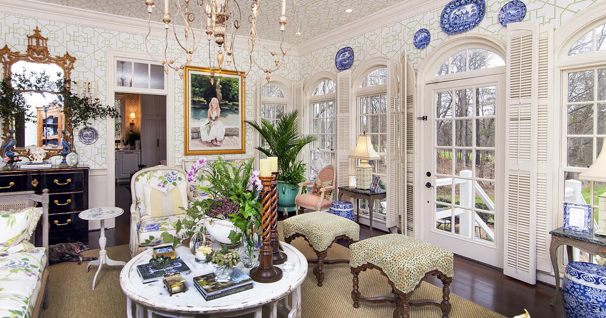Antique sitting area with large windows and white and green wallpaper