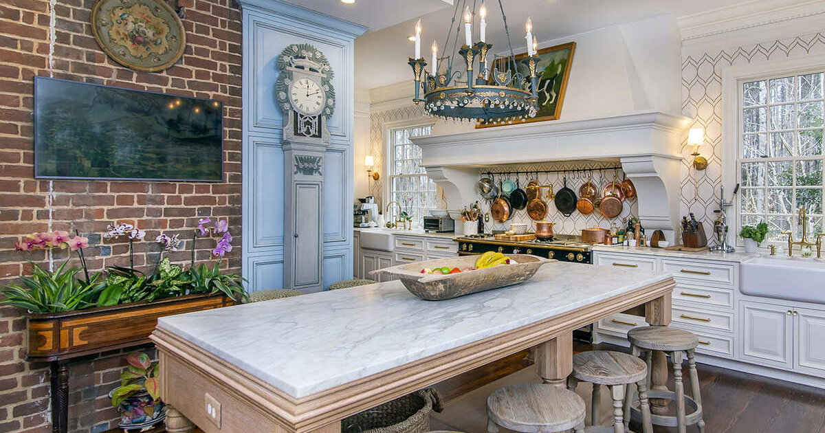 Kitchen cabinets with a brick wall and a large island