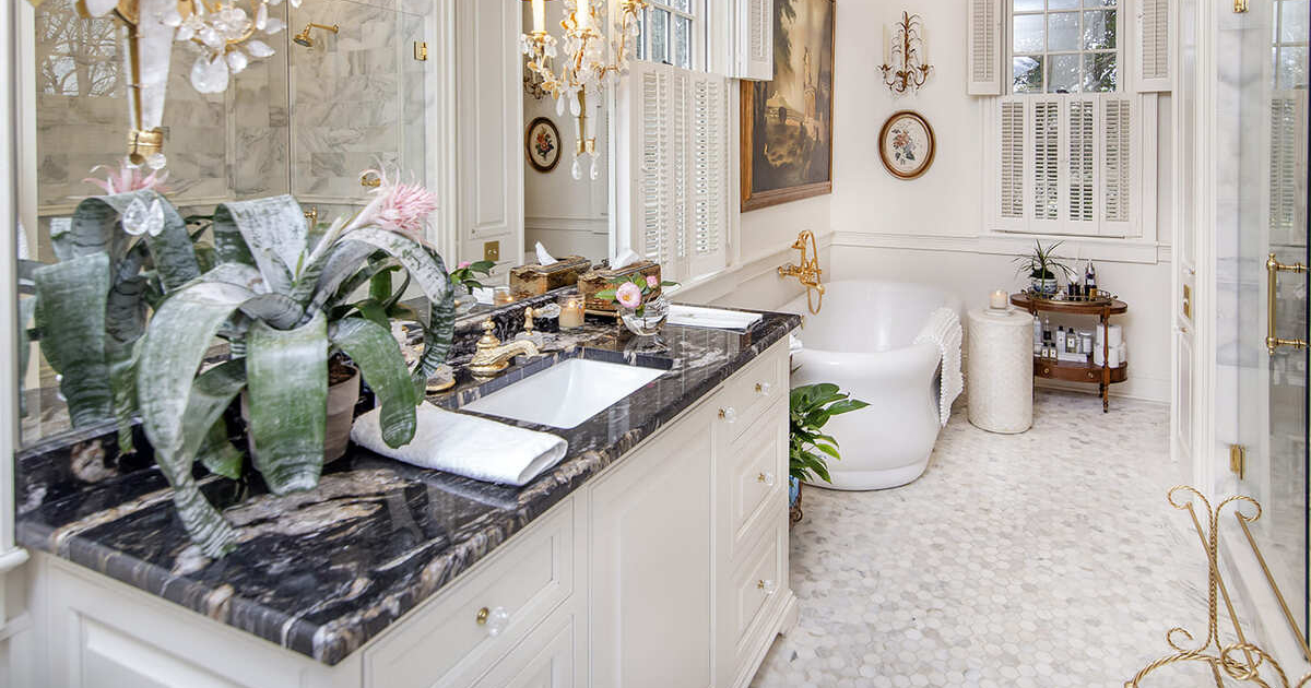 White bathroom cabinets with tile floor and a large tub