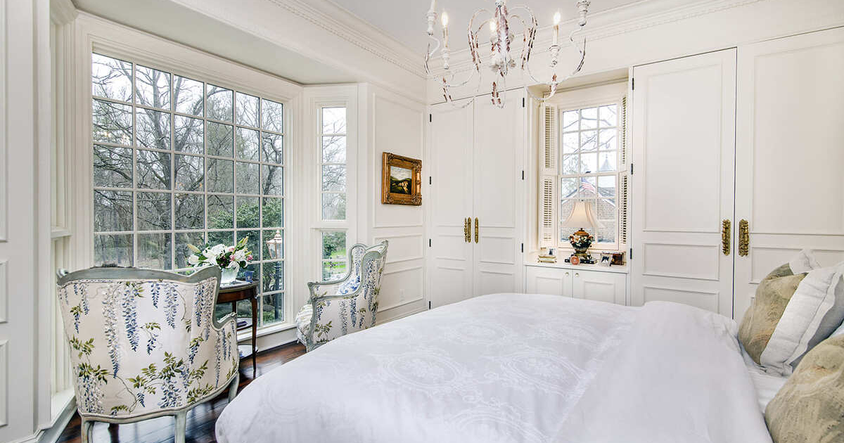 Bedroom with a large light fixture and white closet doors