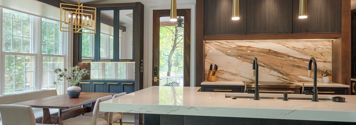 A kitchen with cabinetry and mirrored cabinets with a double sided faucet sink