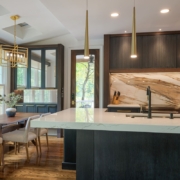A kitchen with cabinetry and mirrored cabinets with a double sided faucet sink