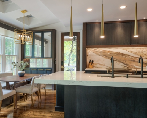 A kitchen with cabinetry and mirrored cabinets with a double sided faucet sink