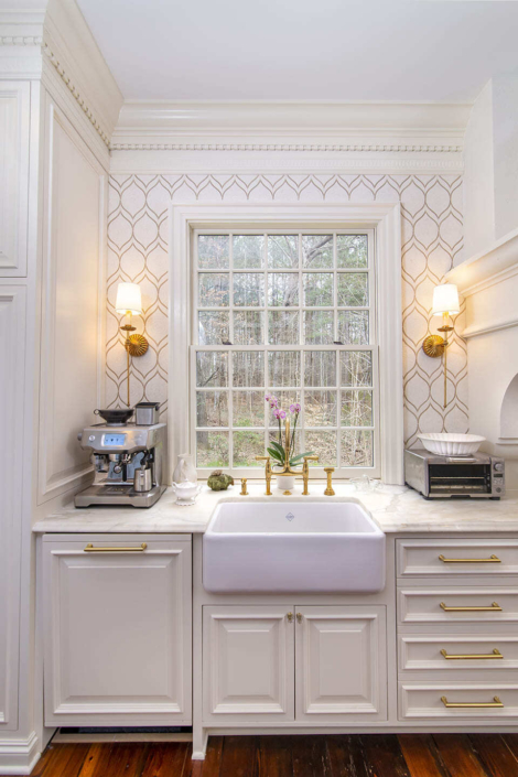 Large window with a sink and gold light fixtures