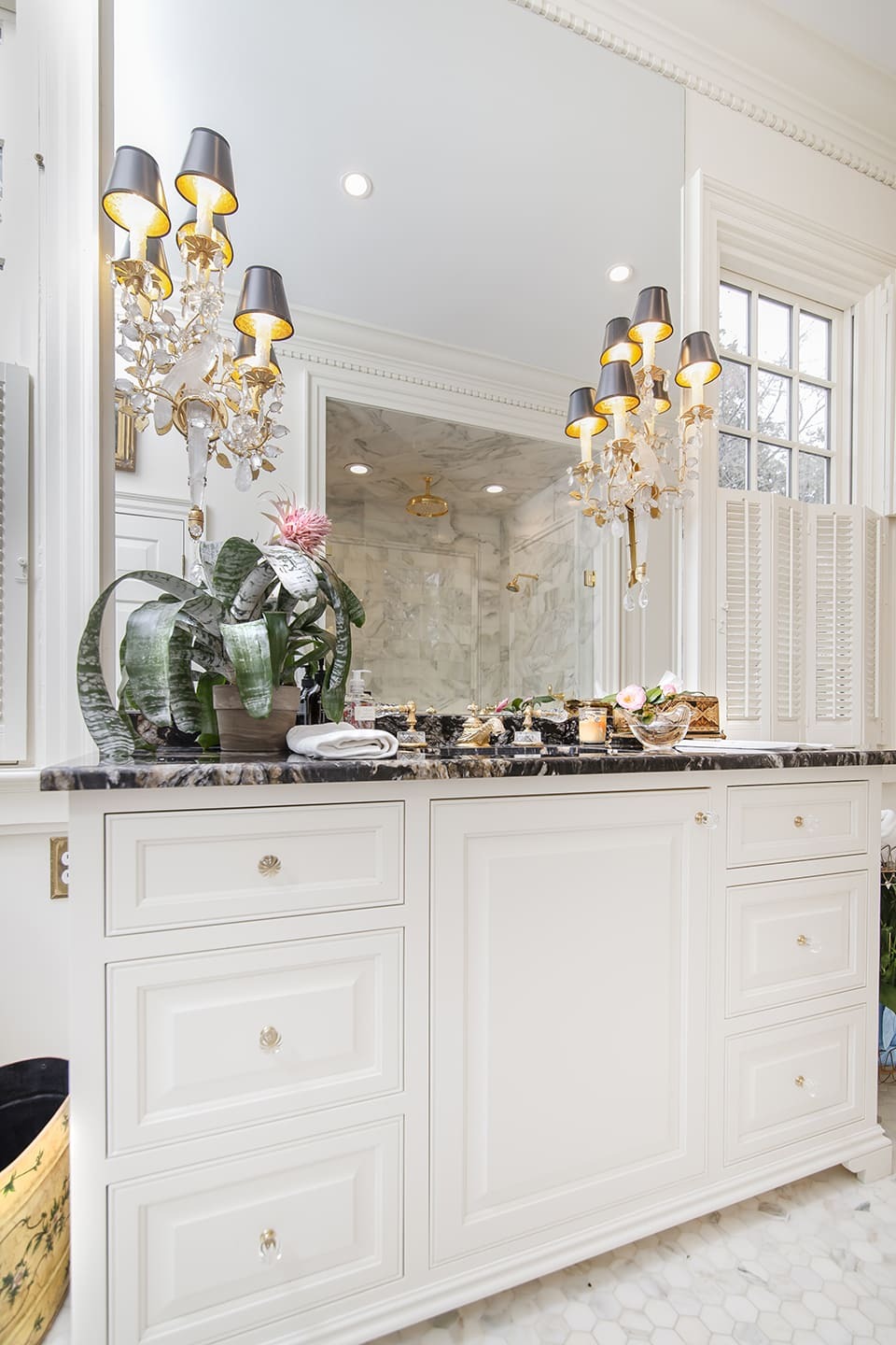 White bathroom vanity with a large mirror and light fixtures
