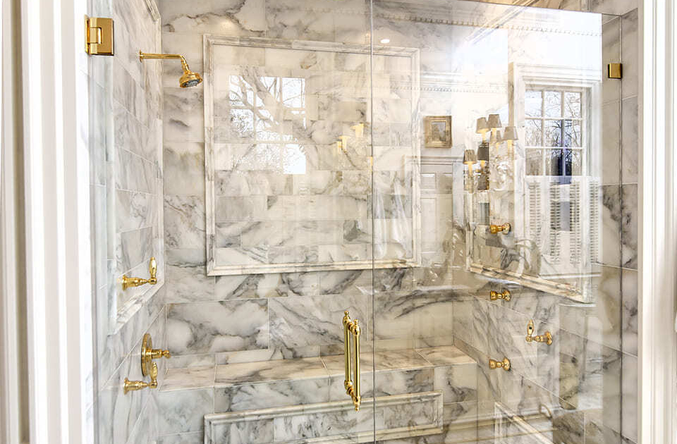 Large walk in shower with glass doors and tile flooring