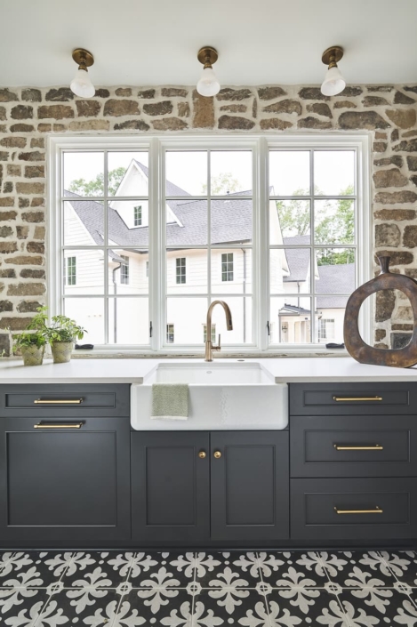 kitchen cabinets with windows and stone backsplash