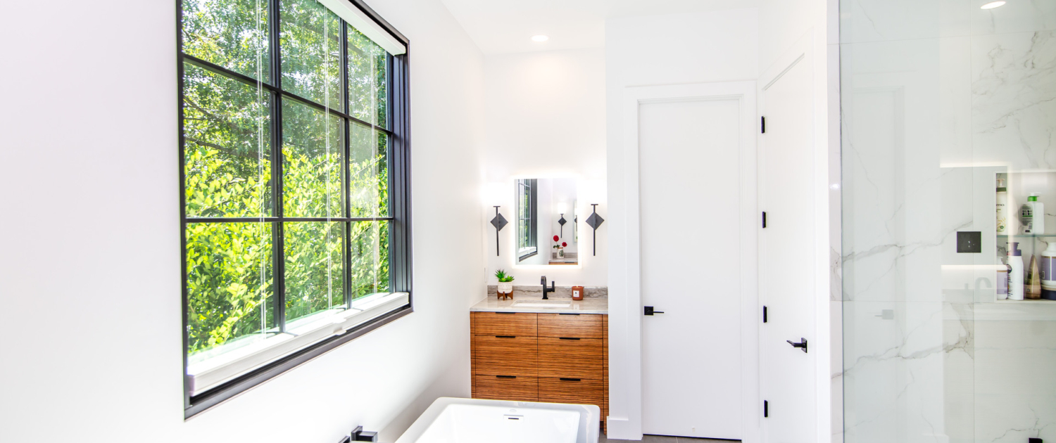A master bathroom with a vanity and cabinets and with a soaker tub