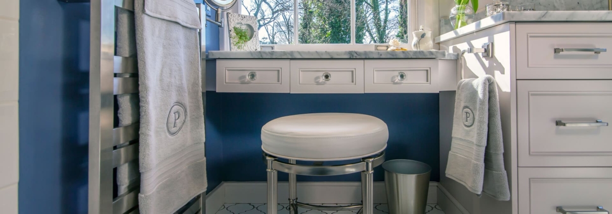 bathroom vanity with seating and a towel warmer