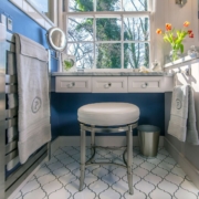 bathroom vanity with seating and a towel warmer