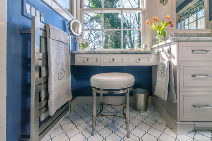 bathroom vanity with seating and a towel warmer