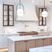 A kitchen with black metal cabinet doors and frameless cabinets with under cabinet lighting