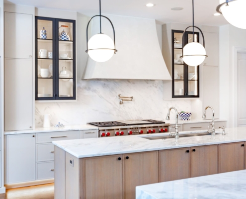 A kitchen with black metal cabinet doors and frameless cabinets with under cabinet lighting