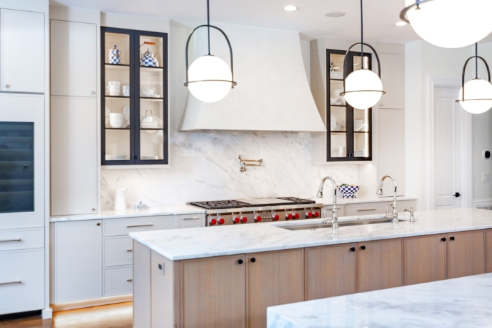 A kitchen with black metal cabinet doors and frameless cabinets with under cabinet lighting