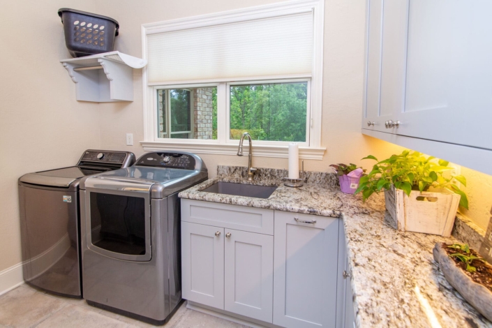 blue laundry room cabinets with a washer and dryer