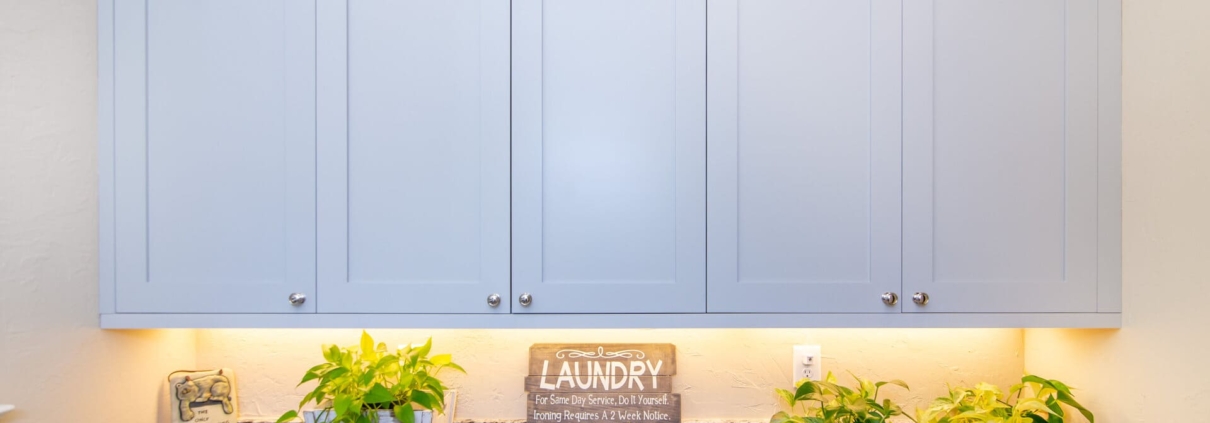 blue laundry room cabinets with lighting