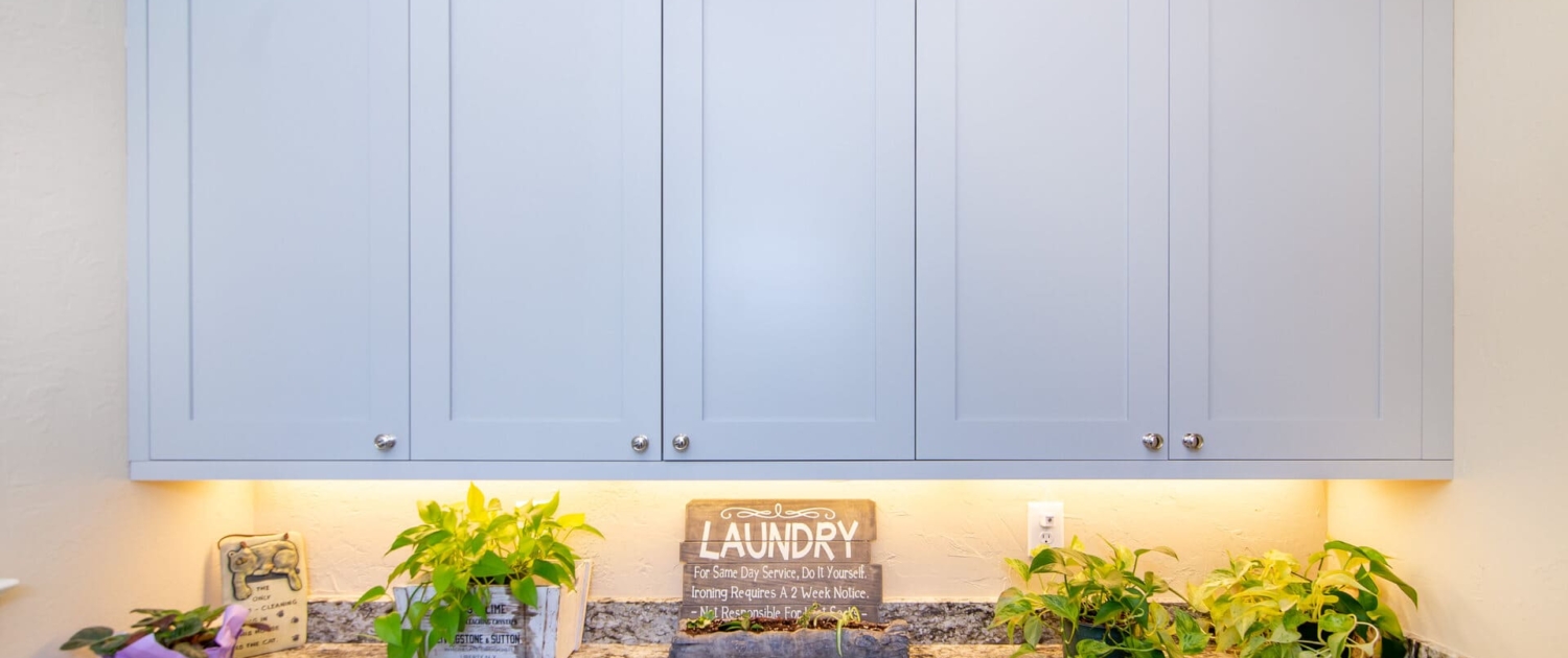 blue laundry room cabinets with lighting