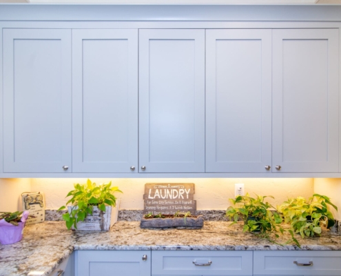 blue laundry room cabinets with lighting
