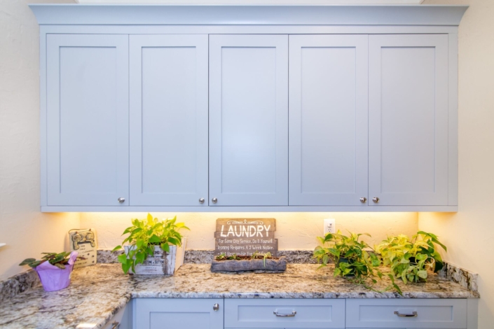 blue laundry room cabinets with lighting