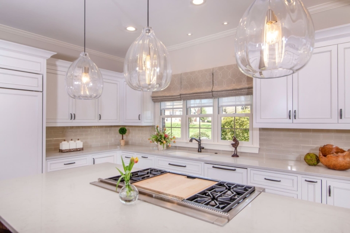 white kitchen with a stove and flowers