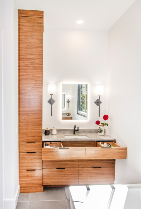 A master bathroom with a tall wall cabinet and a vanity