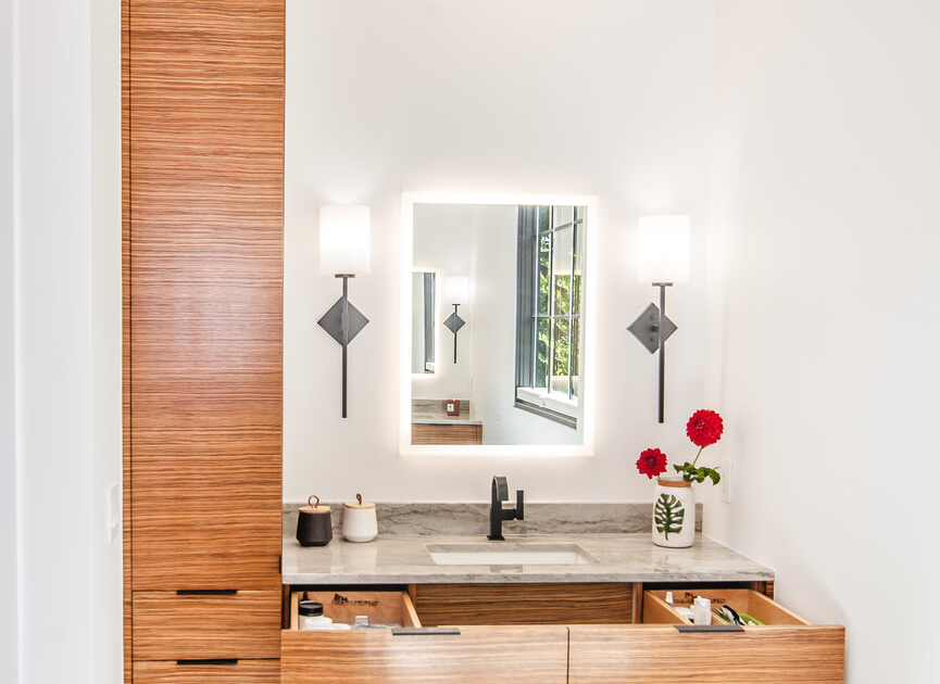 A master bathroom with a tall wall cabinet and a vanity