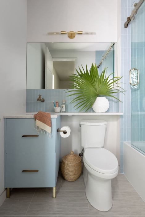 blue bathroom vanity with a large plant