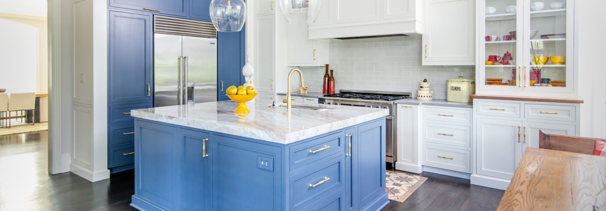 A kitchen with white and blue cabinetry and glass front doors