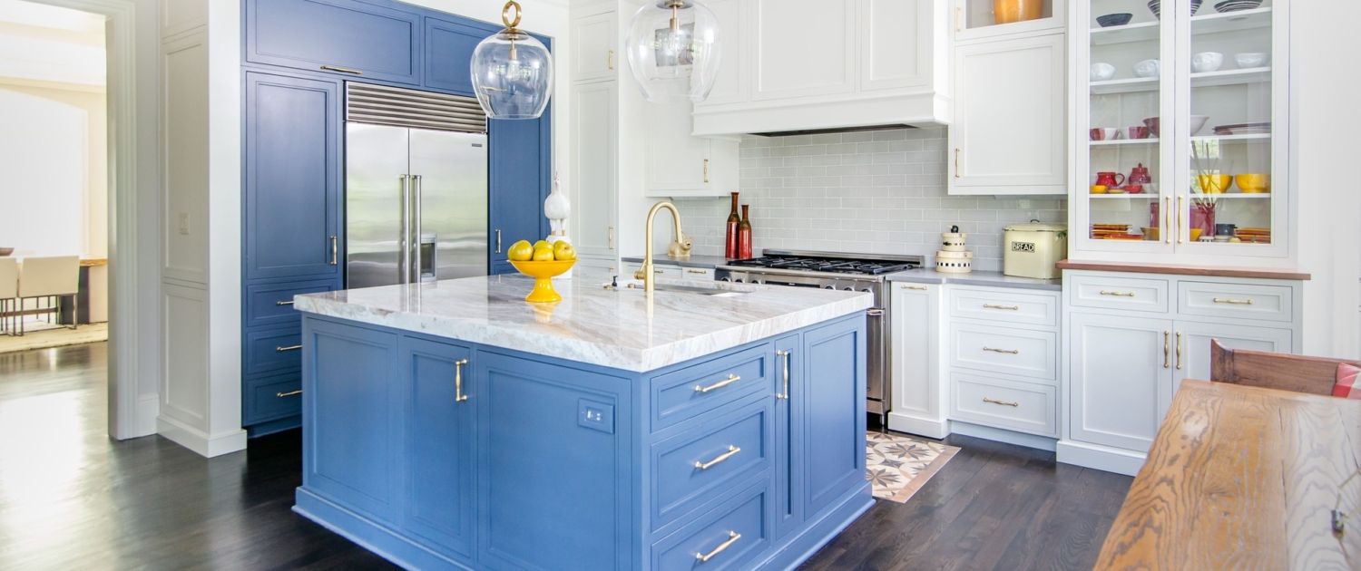 A kitchen with white and blue cabinetry and glass front doors