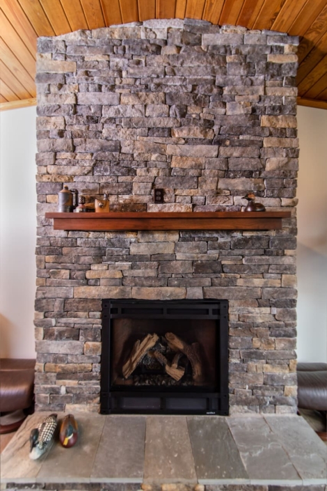 brick fireplace with a floating shelf