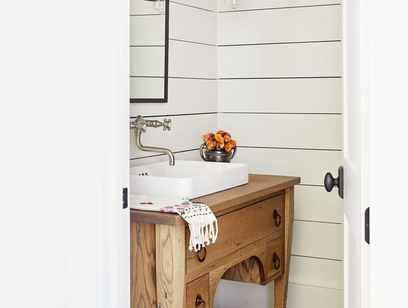 A guest bathroom with a reclaimed bathroom vanity and tile design flooring