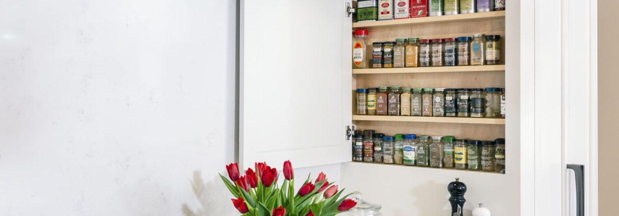 hidden spice cabinet in a white kitchen