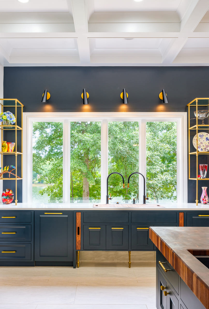 Blue kitchen cabinets with gold hardware and white countertops