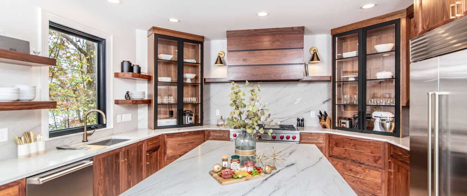 Custom walnut cabinets with gold hardware and white countertops