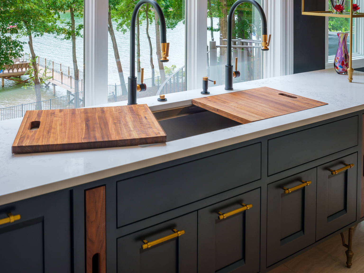 Blue kitchen cabinets with a large sink and white countertops