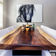 A live edge wooden dining room table with artwork and decor pieces
