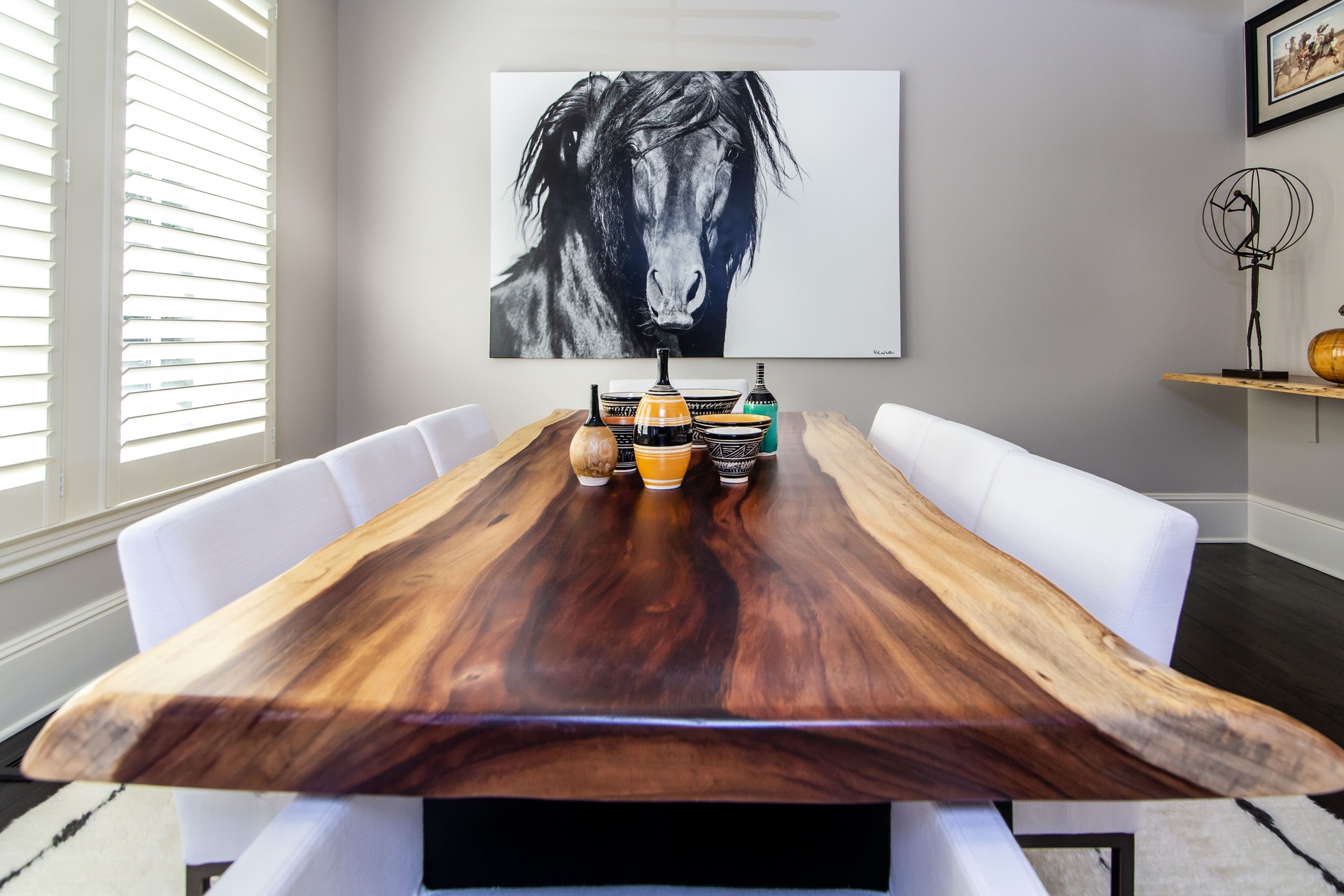 A live edge wooden dining room table with artwork and decor pieces