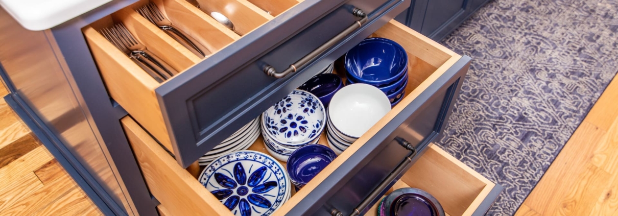 blue kitchen island with dishware in drawers