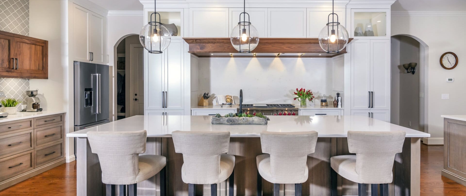 a kitchen island with chairs and a white kitchen