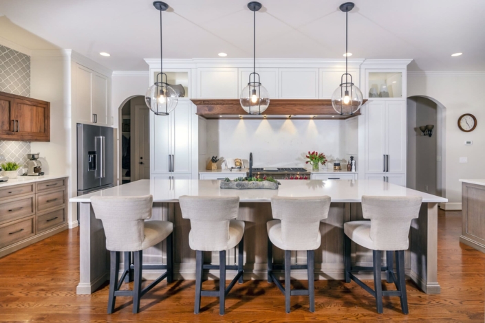 a kitchen island with chairs and a white kitchen