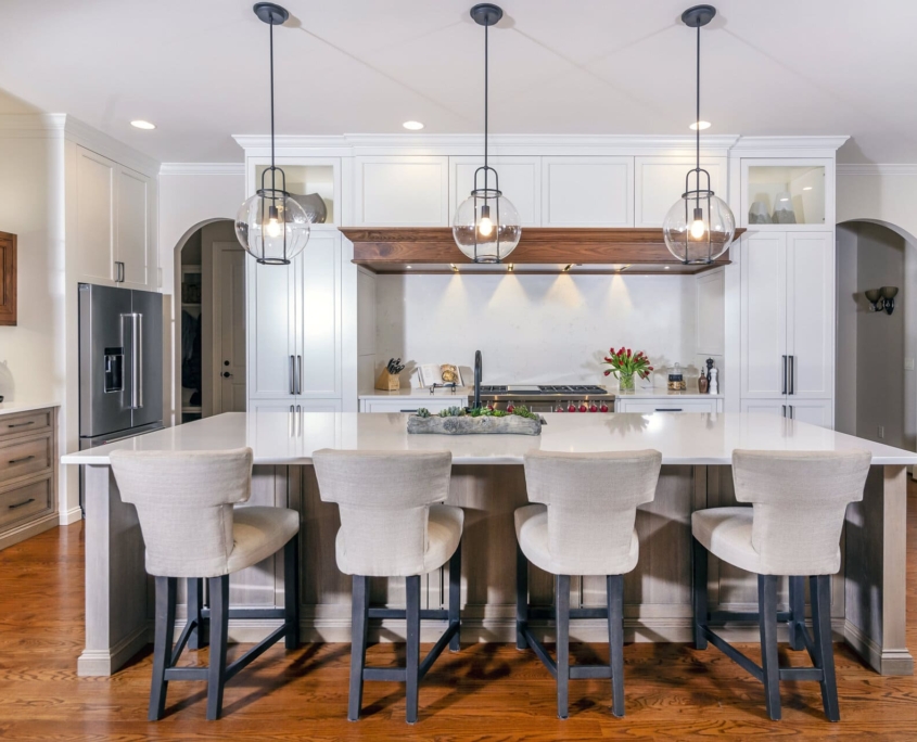 a kitchen island with chairs and a white kitchen