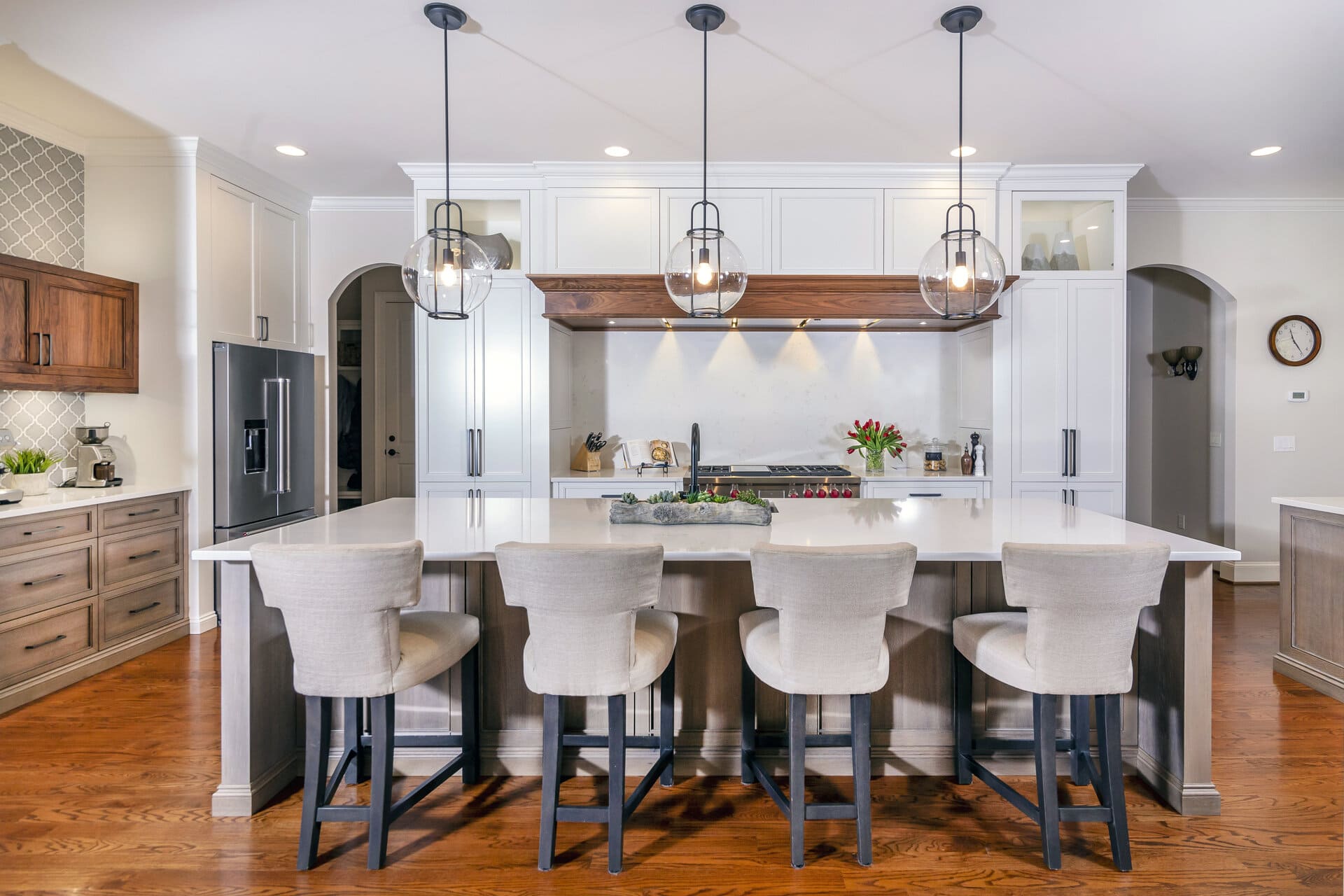 a kitchen island with chairs and a white kitchen